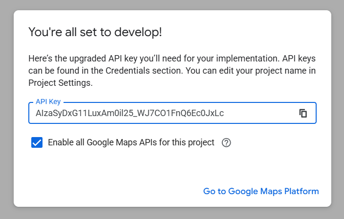 A Google dialog headed You're all set to develop, showing the upgraded API key and a ticked checkbox reading Enable all Google Maps APIs for this project.